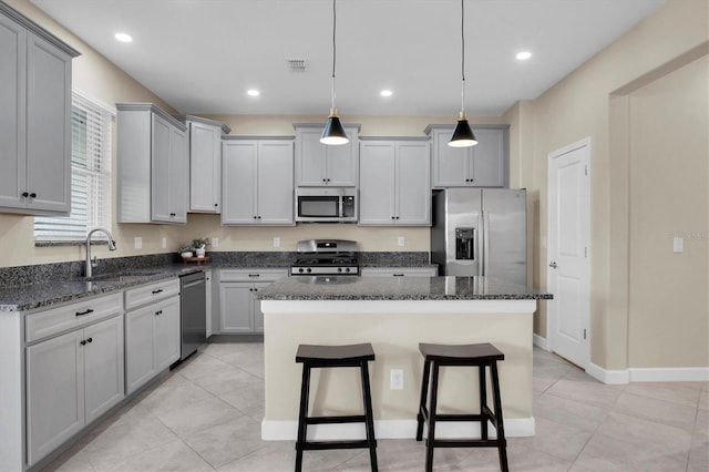 kitchen featuring pendant lighting, a center island, gray cabinets, and stainless steel appliances