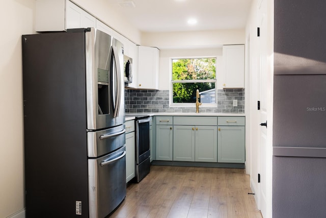 kitchen with white cabinetry, light hardwood / wood-style flooring, stainless steel appliances, and sink