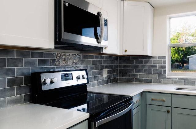 kitchen featuring white cabinets, backsplash, stainless steel appliances, and plenty of natural light