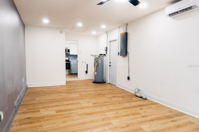 interior space with ceiling fan, electric water heater, light hardwood / wood-style flooring, a wall mounted AC, and electric panel