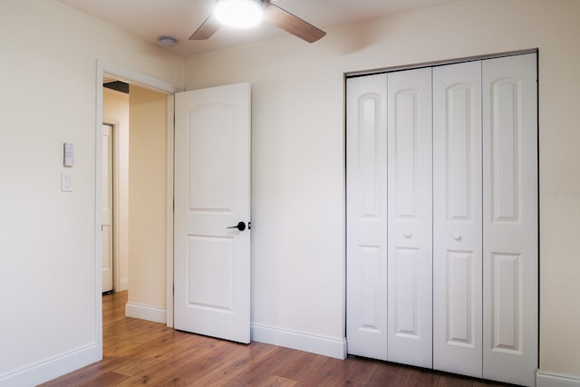 unfurnished bedroom featuring wood-type flooring, a closet, and ceiling fan