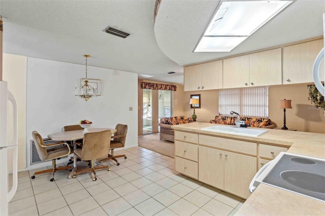 kitchen featuring decorative light fixtures, light tile patterned floors, sink, and range