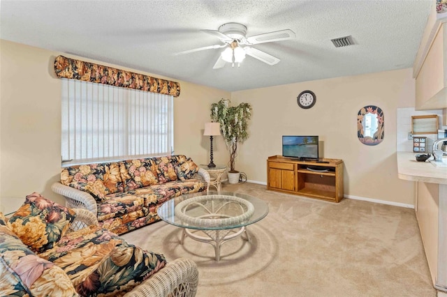 living room featuring a textured ceiling, ceiling fan, and light carpet