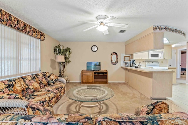 living room featuring sink, ceiling fan, light colored carpet, and a textured ceiling