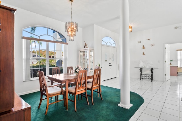 dining space with decorative columns, light tile patterned floors, a healthy amount of sunlight, and an inviting chandelier