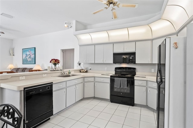 kitchen featuring sink, light tile patterned floors, kitchen peninsula, white cabinets, and black appliances