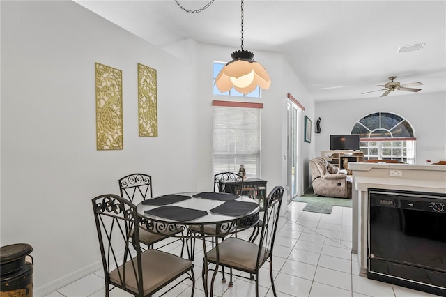 dining area featuring ceiling fan, light tile patterned floors, and vaulted ceiling