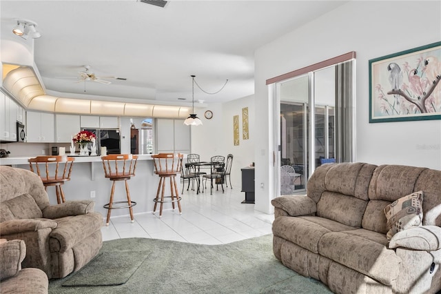 living room featuring ceiling fan and light tile patterned floors