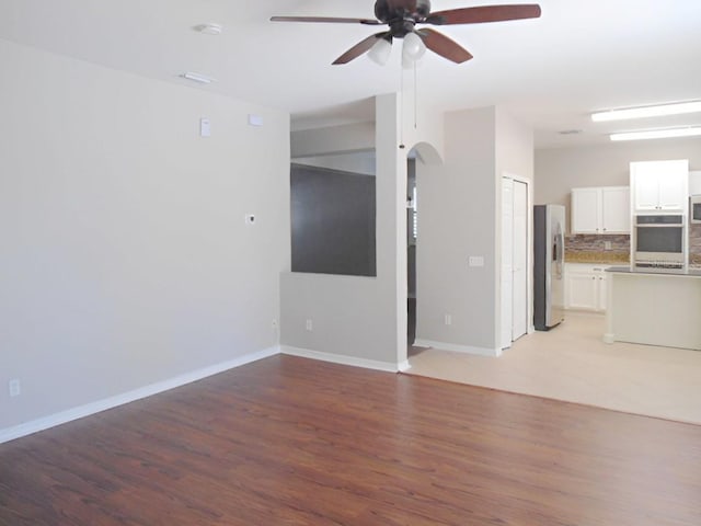 unfurnished living room featuring light hardwood / wood-style floors and ceiling fan