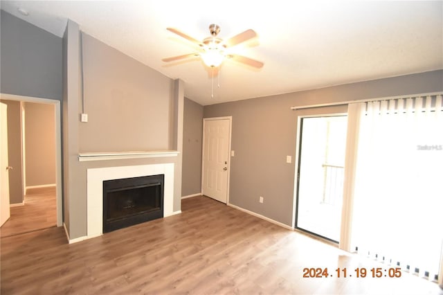 unfurnished living room featuring hardwood / wood-style flooring, ceiling fan, and a tile fireplace