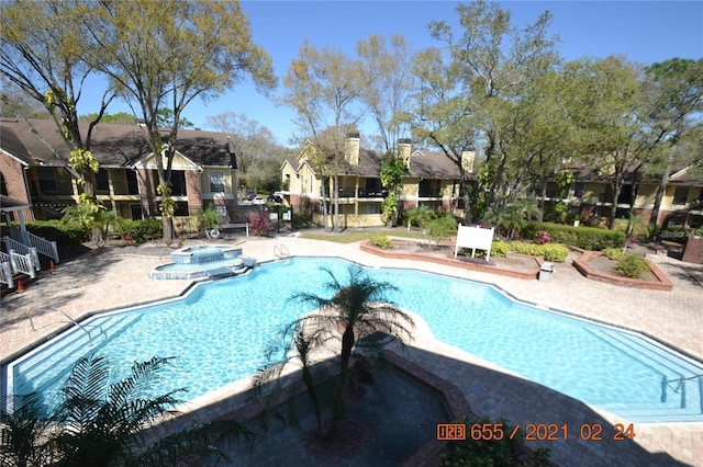 view of pool with a patio area and a hot tub