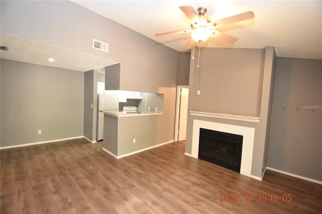 unfurnished living room with a textured ceiling, ceiling fan, lofted ceiling, and dark wood-type flooring