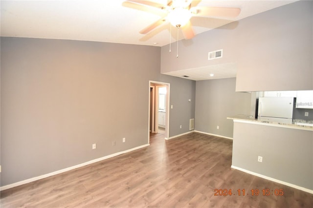 unfurnished living room featuring wood-type flooring, high vaulted ceiling, and ceiling fan