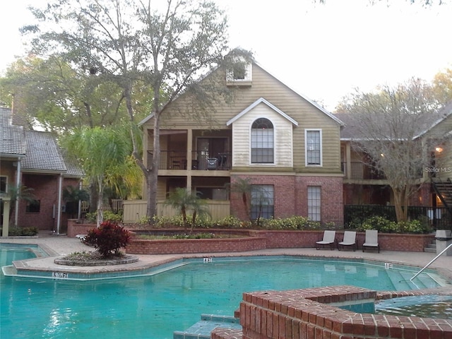 rear view of house featuring a jacuzzi