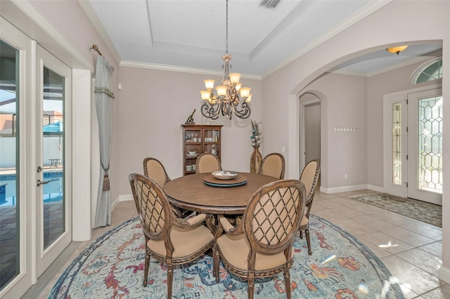 dining space with arched walkways, a chandelier, light tile patterned flooring, baseboards, and a tray ceiling