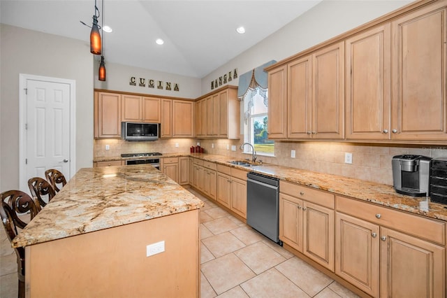 kitchen with light brown cabinetry, stainless steel appliances, a sink, and a center island