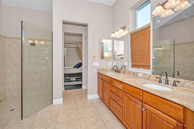 full bath with double vanity, tile patterned floors, a sink, and tiled shower