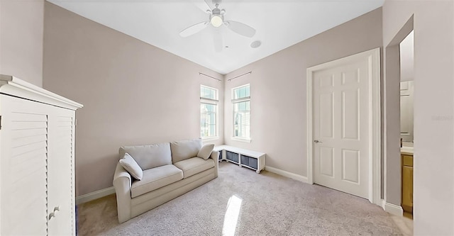 living room featuring ceiling fan, light colored carpet, and baseboards