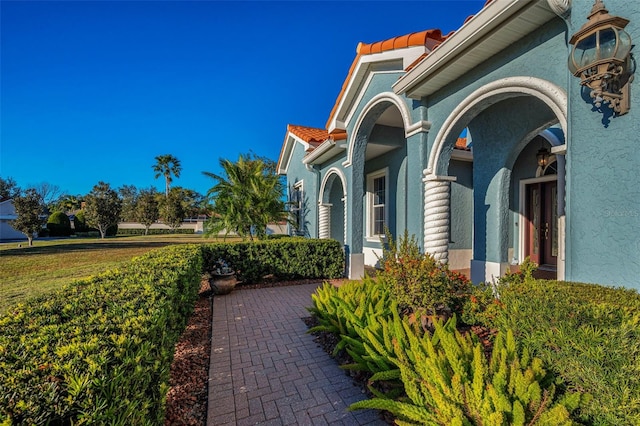 view of home's exterior featuring a tile roof and stucco siding