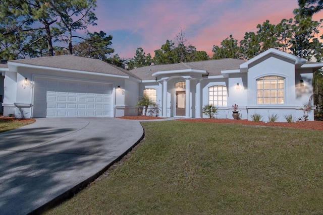 ranch-style home featuring a lawn and a garage