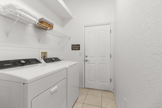 laundry room featuring light tile patterned flooring and separate washer and dryer