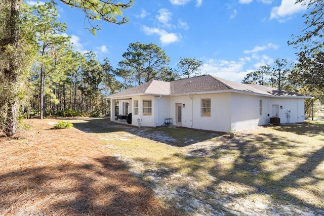 back of house with a yard and central AC