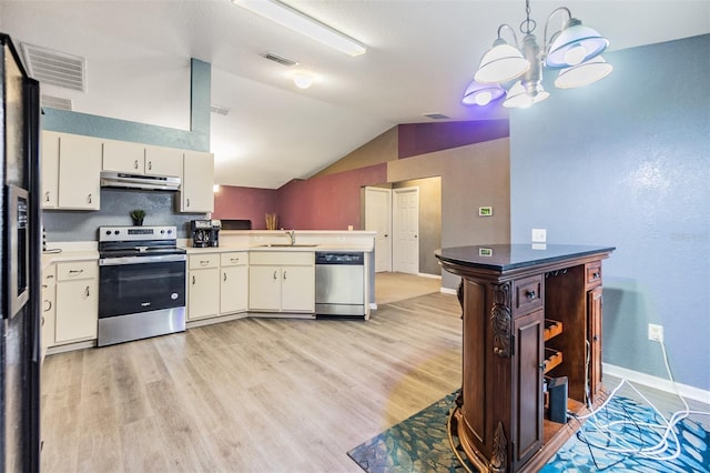 kitchen with light hardwood / wood-style flooring, hanging light fixtures, vaulted ceiling, and appliances with stainless steel finishes