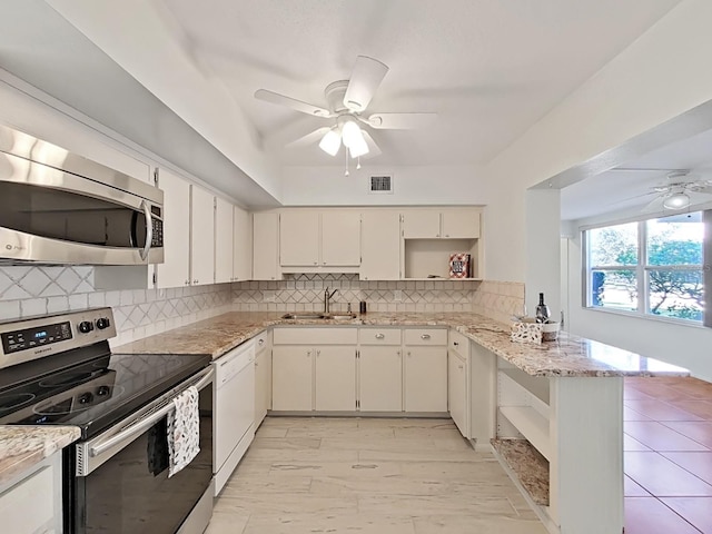 kitchen featuring backsplash, white cabinets, sink, kitchen peninsula, and stainless steel appliances