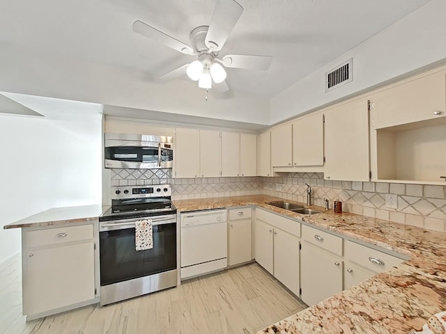 kitchen featuring tasteful backsplash, stainless steel appliances, ceiling fan, sink, and cream cabinets