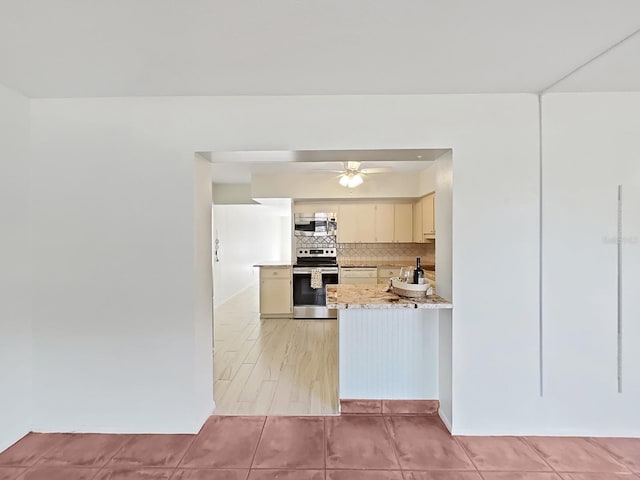 kitchen featuring decorative backsplash, appliances with stainless steel finishes, ceiling fan, light tile patterned floors, and cream cabinets