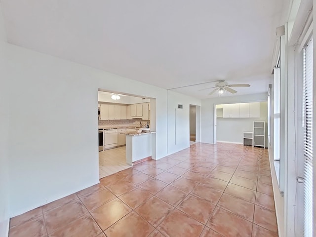 unfurnished living room featuring light tile patterned floors and ceiling fan