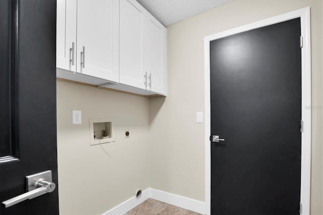 laundry area featuring electric dryer hookup, hookup for a washing machine, cabinets, and a textured ceiling