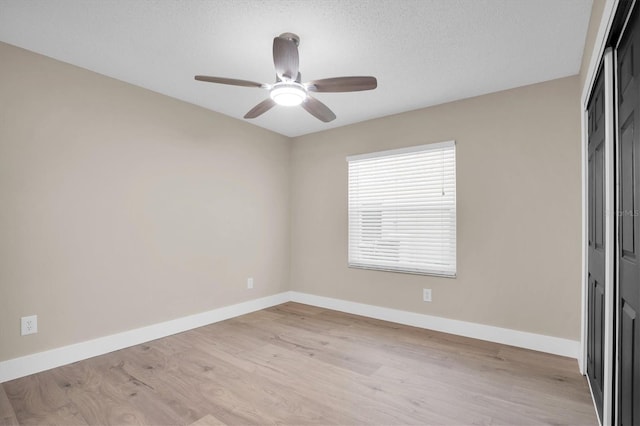 unfurnished room with ceiling fan, light hardwood / wood-style floors, and a textured ceiling