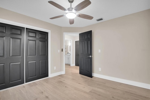 unfurnished bedroom with ceiling fan, light hardwood / wood-style floors, and a closet