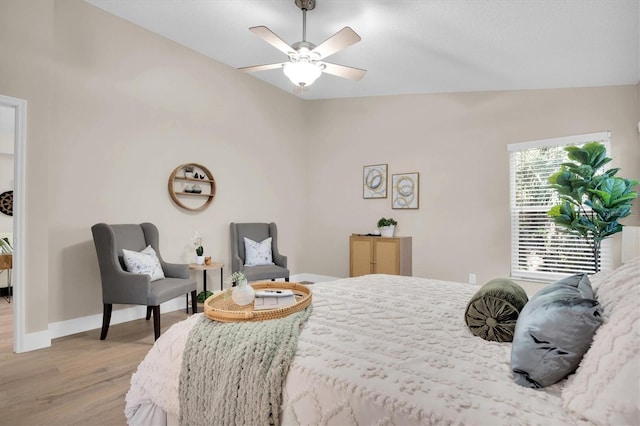 bedroom featuring ceiling fan, light hardwood / wood-style floors, and vaulted ceiling