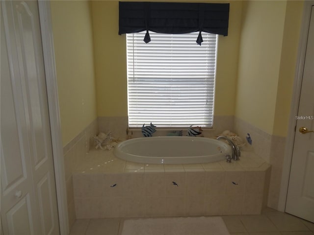 bathroom with tile patterned floors and tiled tub