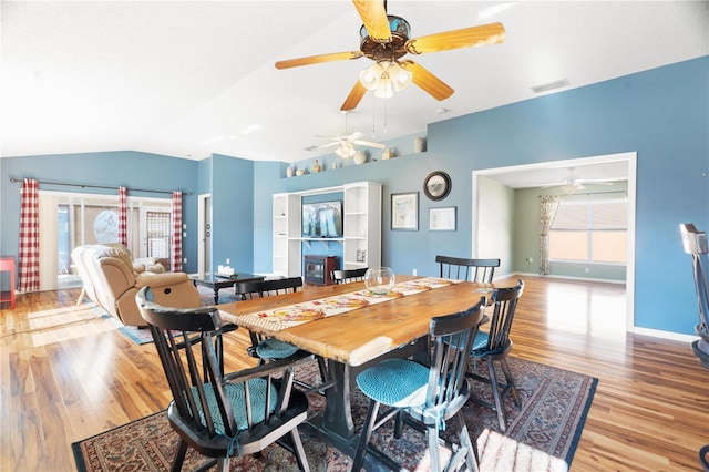 dining room featuring light hardwood / wood-style flooring, vaulted ceiling, plenty of natural light, and ceiling fan