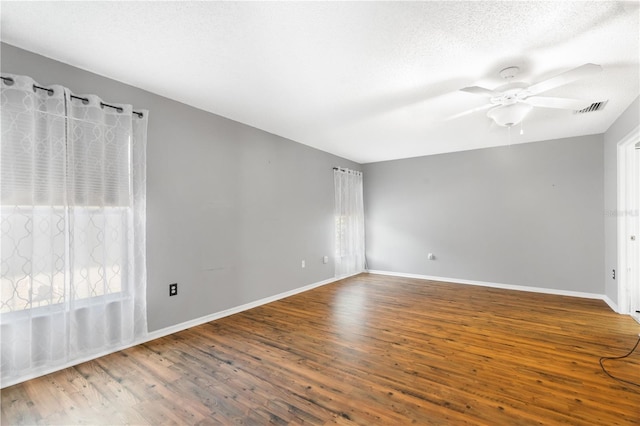 unfurnished room with ceiling fan, wood-type flooring, and a wealth of natural light