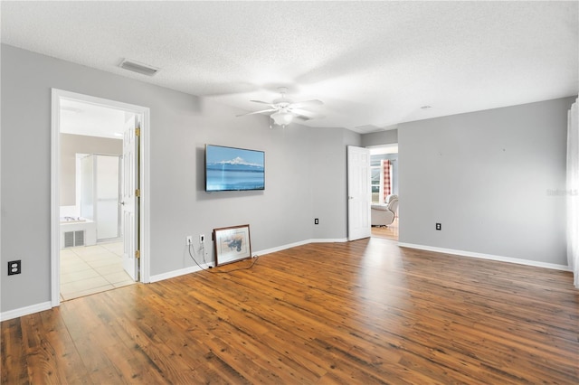 empty room featuring ceiling fan, a textured ceiling, and light wood-type flooring