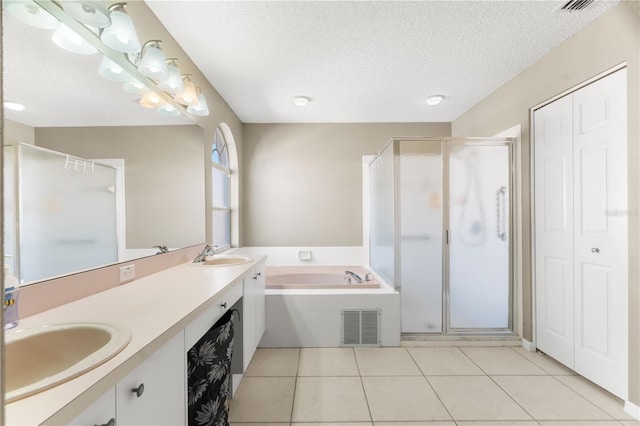 bathroom with tile patterned floors, vanity, a textured ceiling, and independent shower and bath