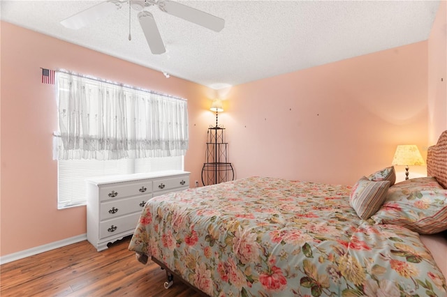 bedroom featuring multiple windows, a textured ceiling, light hardwood / wood-style floors, and ceiling fan