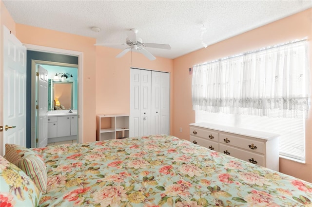 bedroom with connected bathroom, ceiling fan, sink, a textured ceiling, and a closet