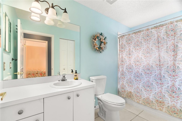 bathroom with tile patterned floors, vanity, a textured ceiling, and toilet