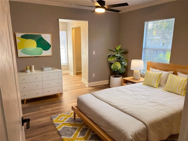 bedroom featuring crown molding, ceiling fan, and light wood-type flooring