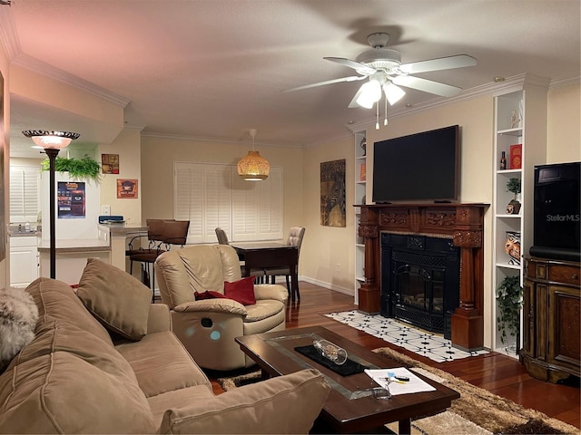 living room with hardwood / wood-style floors, built in features, ceiling fan, and ornamental molding