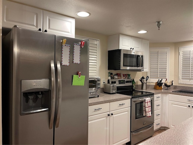 kitchen featuring white cabinetry, appliances with stainless steel finishes, sink, and a textured ceiling