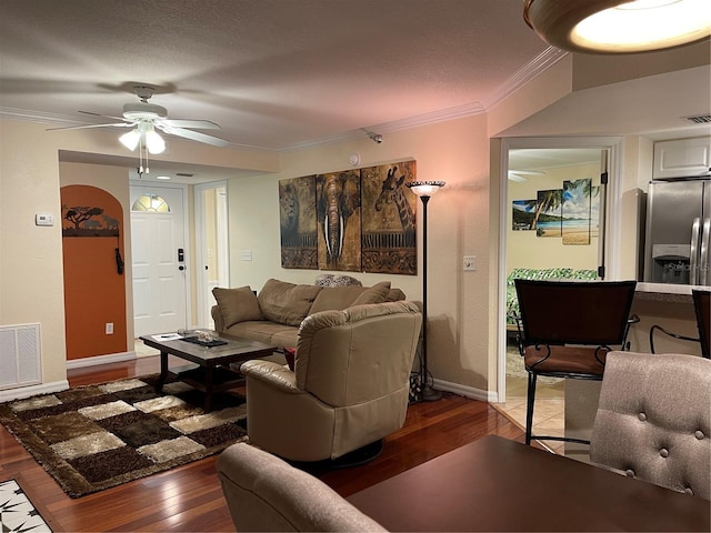 living room featuring crown molding, dark wood-type flooring, and ceiling fan