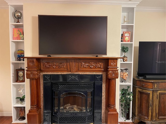 details with ornamental molding, hardwood / wood-style floors, a fireplace, and built in shelves