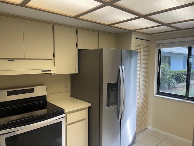 kitchen with ventilation hood, light tile patterned floors, stainless steel appliances, and cream cabinets