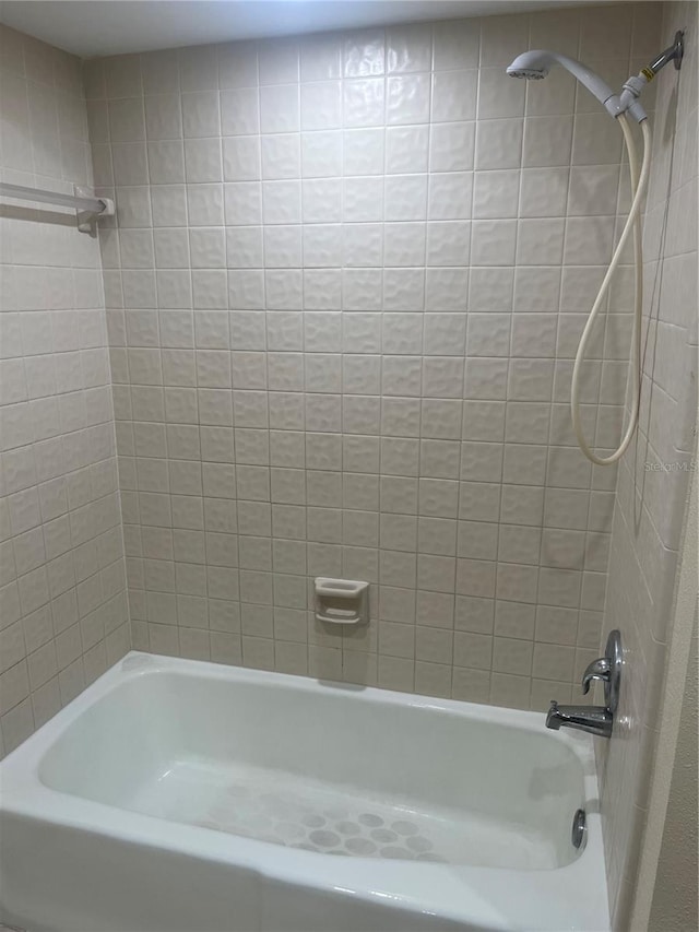 bathroom featuring tiled shower / bath